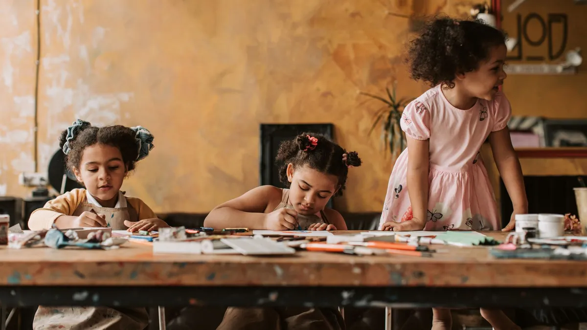 Enfants qui font des activités manuelles et du bricolage à une table, à la maison