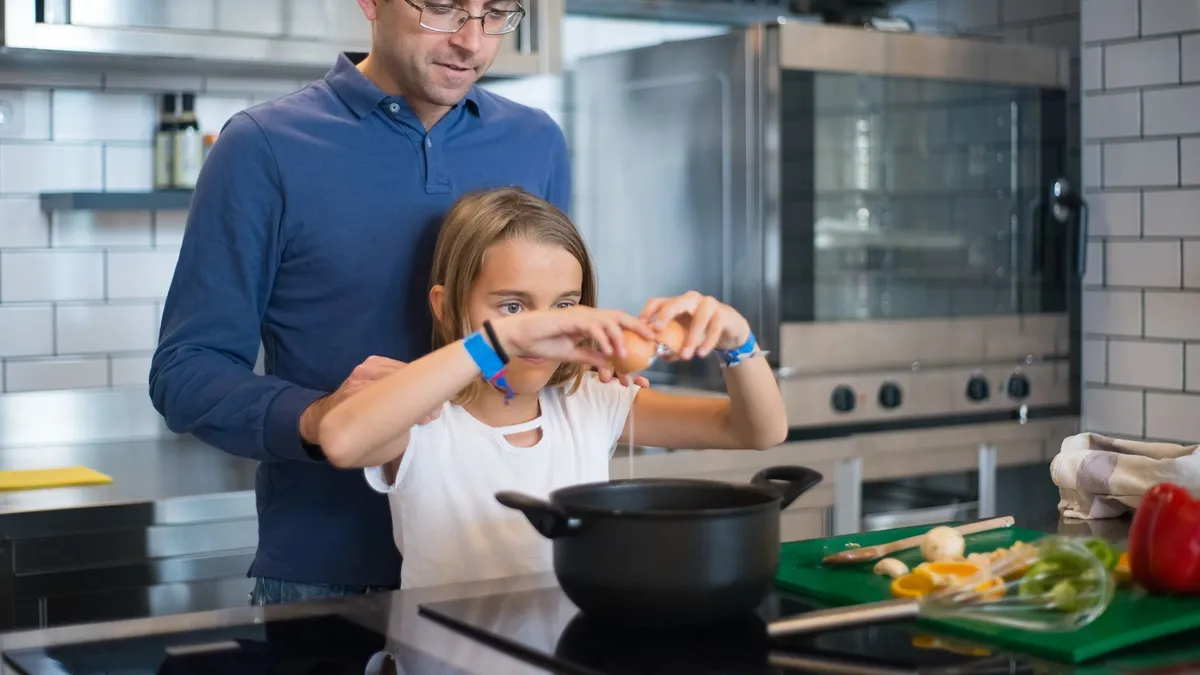 Un parent et son enfant qui cuisinent ensemble, une compétence de la vie quotidienne