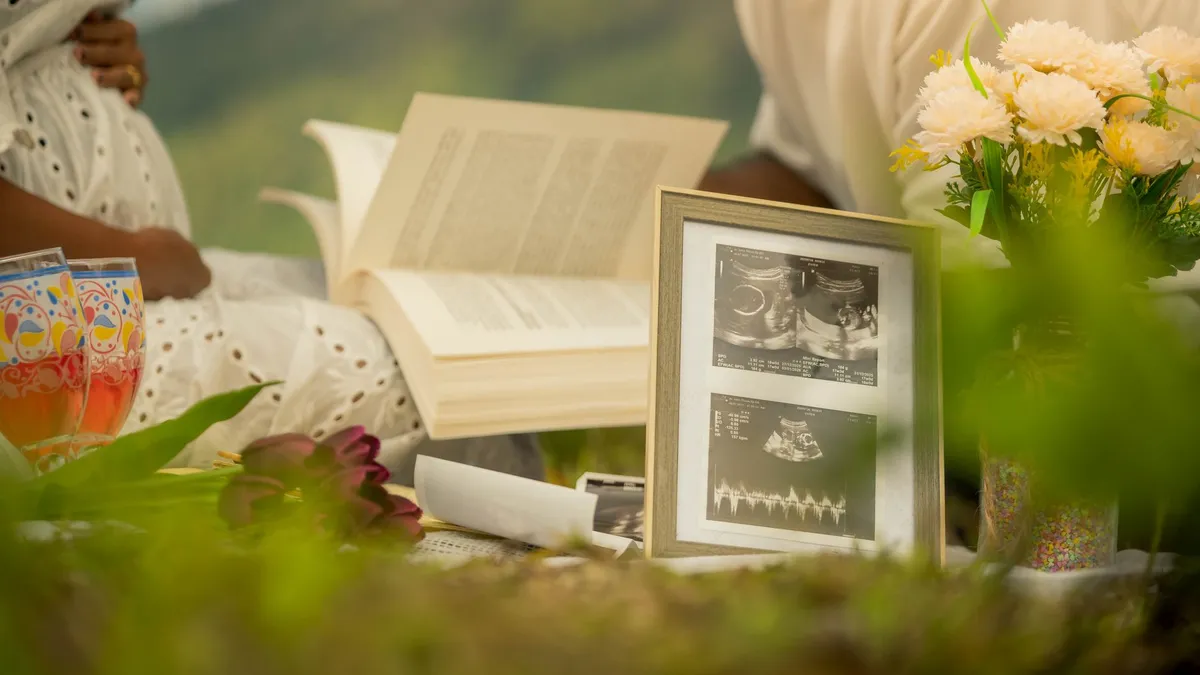Couple qui lit ensemble en attendant bébé, avec une échographie